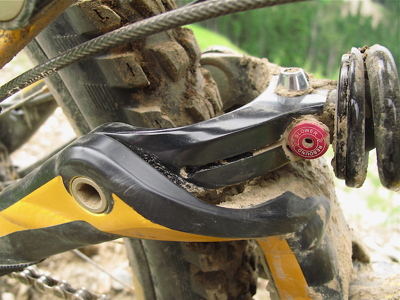 The new shock yoke allows Specialized to mount the shock where it simply wasn't possible before - through the tire! This new position not only lowers the center of gravity, but also lets the engineers fine tune the suspension rate exactly to their liking, which is more progressive than previous Demo's. The rearward shock eyelet is rotated 90 degrees and the shock mounting bolt runs vertically, not horizontally. Also notice the Whistler terra firma from doing Garbonzo runs splattered nearly everywhere - This bike got some major vertical today!