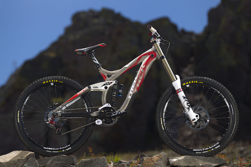 Do bikes get any more stunning than this looker? This is Trek's 2011 Session 88, a machine that apparently has no qualms about both looking great and being fast as hell. While the 88's lines look very similar to previous year's offerings, there are many big changes that have been made in the name of all out speed and control. Trek has employed a brand new large diameter downtube that has a much taller (and more aerodynamic) cross section, a lighter toptube and seattube, new box section stays that give added tire clearance, and even some very clean looking integrated fork bumpers. That's all well and good, but you tech heads out there may be most interested in the very special tuning that has been done to the Fox DHX RC4's insides, which you can read and hear more about down below. All the new frame and shock changes are great, but I know some of you are still staring at the new bike's graphics instead of reading these words. You'd be mistaken if you thought that the bike has a matte gray finish to it, it's actually bare brushed aluminum with red and white highlights and finished off with a protective clear-coat. Can a bike be considered hot? Apparently so.