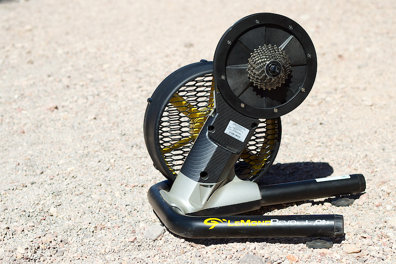 The Revolution trainer doesn't look anything like your current bike trainer. LeMond Fitness takes a different approach to trainer design in that the Revolution doesn't rely on your bike's rear wheel, with your bike attaching to the Revolution's upright that consists of the drive wheel with the cassette bolted in the same place that you'd find on on a standard wheel. But why not just use the wheel that is already on your bike? One of the issues with using a mountain bike wheel with a standard trainer is the knobby tire rolling on the trainer wheel that creates a load of noise, as well as a rough feeling. Swapping your wheel out is one solution, as is changing your tire, but in the end both are less than ideal. The Revolution doesn't wear out your rear tire or expensive cassette, but your bike is also clamped in place just as it would be if your wheel was in the frame so it is more stable than that usual side clamping methods found on most trainers. The cassette pictured is actually part of the trainer (it uses a standard Shimano freehub that will fit any speed cassette and is available with or without one from the factory, a Campagnolo version will be available soon as well) and stays put on the unit. Simply drop your rear wheel out and set the dropouts onto the Revolution as if it was a wheel and you're ready to roll.