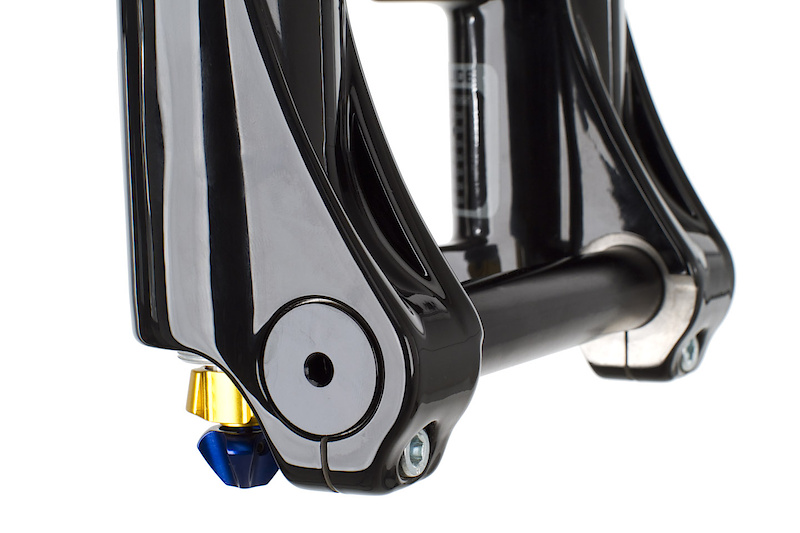 You won't find a fancy quick release axle system on the Vengeance which may put off some riders, but others will prefer the standard and secure looking pinch bolt system that X-Fusion has chosen to use. I can't think of a time when I was racing to get my front wheel off to fix a flat on my all-mountain bike anyhow. A 5 mm allen key is required to loosen the single pinch bolts on each side, as well as thread the axle from the lowers. This photo also shows the low and high speed compression knobs that are located at the bottom of the right leg. Both are clearly labeled and protected from damage by a threaded aluminum cap. Rebound is adjusted via the red aluminum knob atop the right fork leg. All three adjusters use highly defined detents to eliminate guessing when it comes to time make adjustments. You'll find an air pressure chart at the bottom of the left leg to give you a good starting point. The finish is as good as any other high end fork on the market, all knobs are aluminum, and an internal inspection would reveal that there are no cheap plastic parts hidden from view.