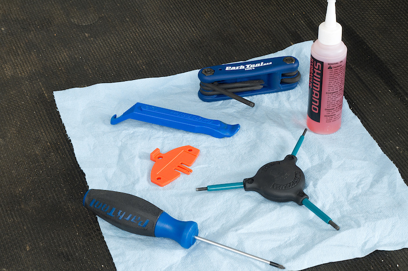 You'll need a plastic tire lever, some hex keys, a small phillips screwdriver, a clean rag, and the red Shimano pad spacer.