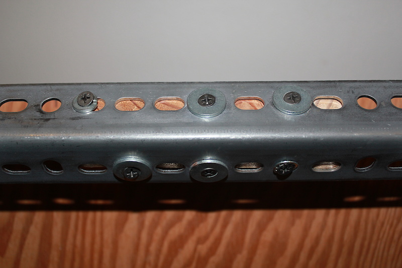 The 2 x 4 pieces are attached to the metal plate with a number of screws and washers. Inexpensive and effective.