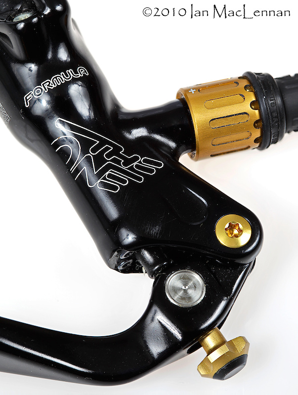 The IRA dial on the lever adjusts the lever's reach, while the in-line barrel-adjustment where the hose exits the brake reservoir is the FCS bite-adjustment function. Both are optional.