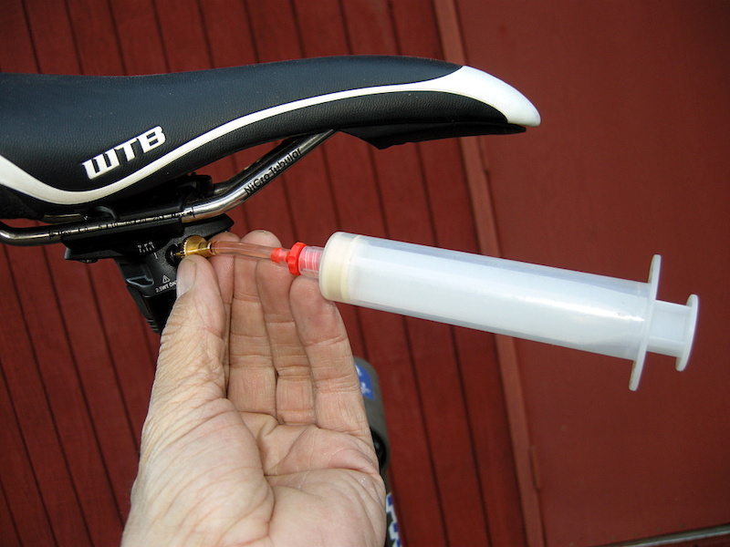 Screw in empty syringe into seatpost bleed port.