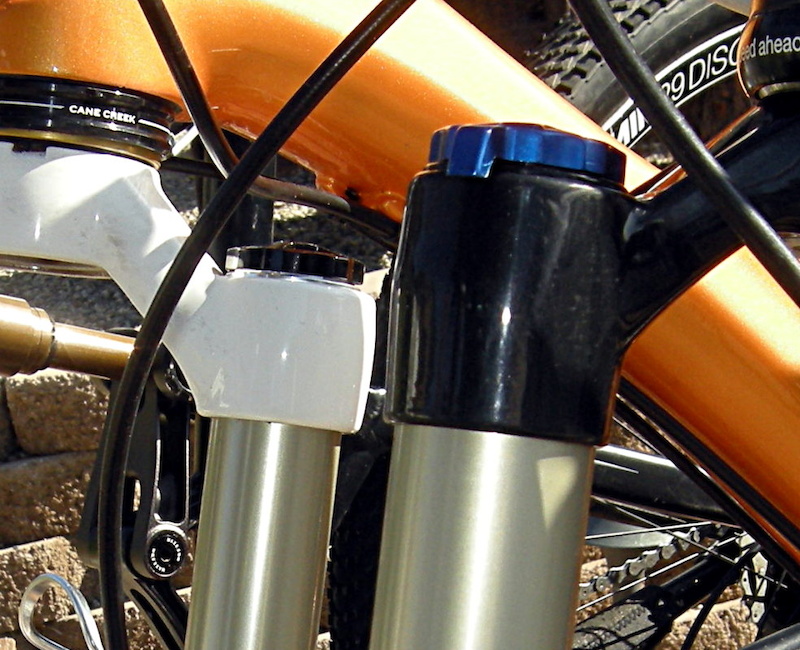 The 34-millimeter stanchion tubes required a different crown design. The longer socket on the right belongs to the 2013 fork while the shorter socket of the white crown belongs to the current Velvet fork.