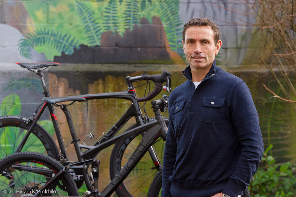 David Labistour CEO of Mountain Equipment Coop stands in front of the Ghost AMR Lector 7700 and a Ghost road bike.